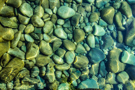Pebbles in stream, transparent water as abstract backgroundの写真素材