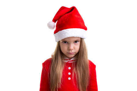 Serious and angry christmas girl wearing a santa hat isolated over a white backgroundの写真素材