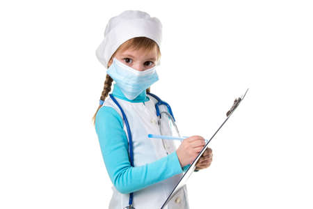 Female medical doctor or nurse with stethoscope and mask write a note in notebook against white background, looking at the camera.の写真素材
