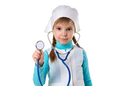 Girl nurse in white uniform with stethoscope in the ears. Listens holding stethoscope on the foreground, distant landscapeの写真素材