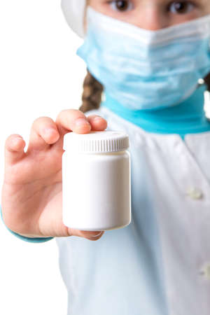 Medicine white pill bottle in the hand of female nurse, isolated on a white backgroundの写真素材