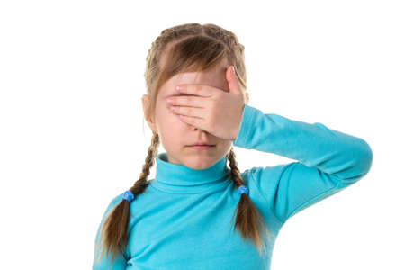 Serious girl closes eyes with her left hand, isolated on the white backgroundの写真素材
