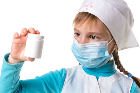 Attractive young female doctor pointing at white pill bottle isolated on white backgroundの写真素材