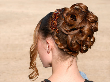 young woman and her beautiful hairstyle for ceremony 