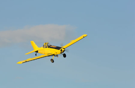 A corp duster or agricultural aircraft flying in a blue skyの写真素材
