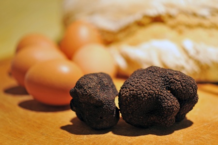 black truffles (tuber melanosporum) on a table with eggs and bredの写真素材