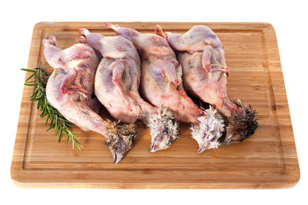 four quails carcasses on a cutting boardの写真素材