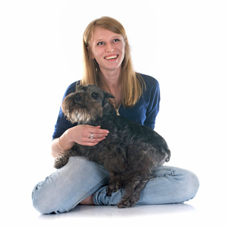 woman and miniature schnauzer in front of white background