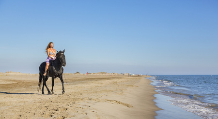 riding girl are training her horse on the beachの写真素材