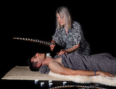 man and energy healing in front of black backgroundの写真素材