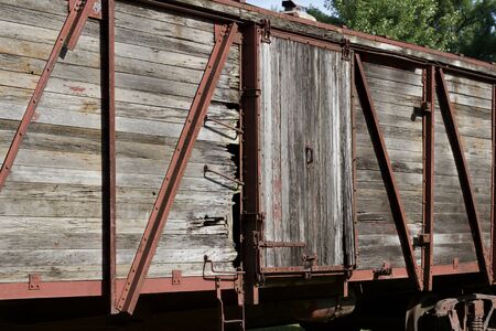 Close up view of an antique red painted railroad train box car showing severe deteriorationの写真素材