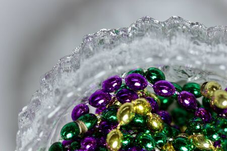 Macro abstract view of traditional three-color Mardi Gras beads inside a crystal bowlの写真素材