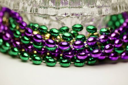 Macro abstract view of traditional three-color Mardi Gras beads around a crystal bowlの写真素材