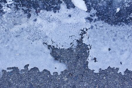 Macro view of melting snow on an asphalt road surfaceの写真素材