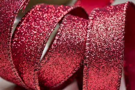 Macro defocused abstract background of red fabric glitter ribbon texture with bokehの写真素材