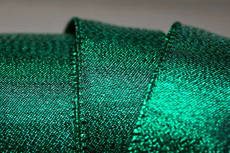 Macro abstract texture background of shimmering metallic green holiday fabric gift wrapping ribbonの写真素材