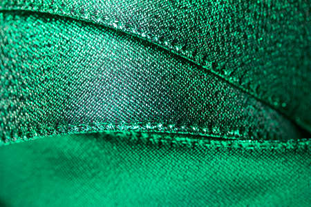 Macro abstract texture background of shimmering metallic green holiday fabric gift wrapping ribbonの写真素材