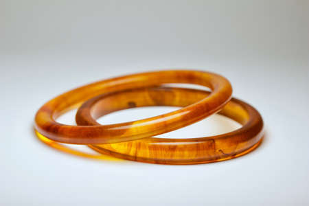 Close up view of two vintage tortoise shell bakelite bangle bracelets on white background, with copy spaceの写真素材