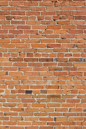 Grungy antique brick wall background with crumbling texture and minor staining
