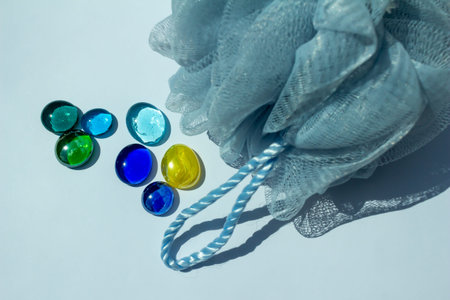 Abstract art texture background of colorful glass bead dragon tears and a blue mesh bath spa sponge...