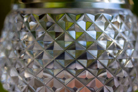 Macro abstract view of beautiful lead crystal glass texture with hand cut diamond pattern facets, reflecting natural outdoor lightの写真素材