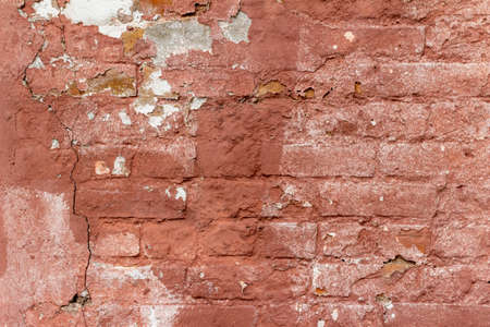 Full frame texture background of an old deteriorating rosy brown painted brick wall with a rugged shabby chic appearanceの写真素材