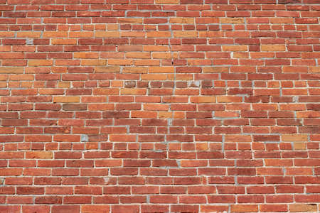 Full frame texture background of a grungy old deteriorating reddish brown clay brick wall, in common bond brickwork patternの写真素材