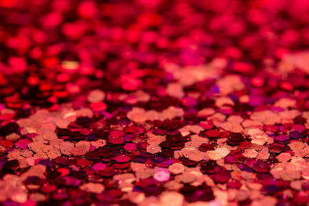 Full frame macro abstract art background of sparkling deep red glitter texture, with bokehの写真素材