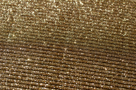 This image shows a full frame macro abstract texture of shimmering gold glitter corrugated surface background.の写真素材