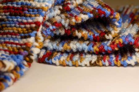 This image shows a full frame abstract texture background of hand knitted yarn scarf in a garter stitch, with a bright multi-colored pattern.の写真素材