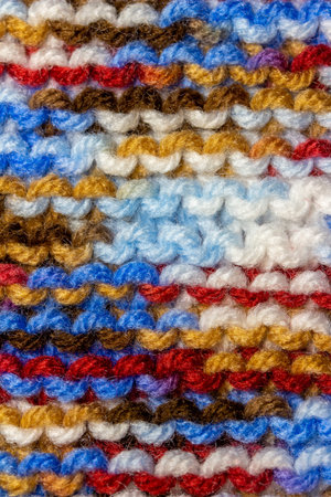 This image shows a full frame abstract texture background of hand knitted yarn cloth in a simple...