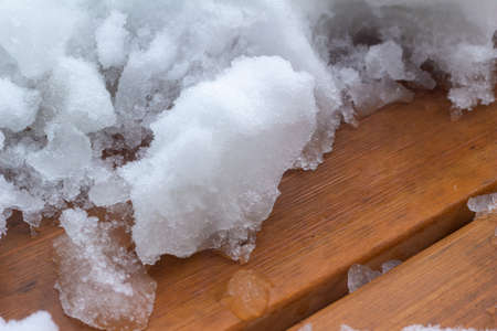 This image shows an abstract texture view of partially shoveled deep snow on a wooden deck following a blizzard.の写真素材