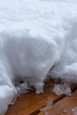 This image shows an abstract texture view of partially shoveled deep snow on a wooden deck following a blizzard.の写真素材