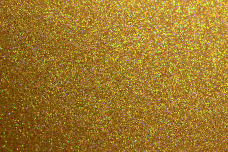 This image shows a full frame macro photographed sparkling champagne color glitter surface background with bokeh.の写真素材