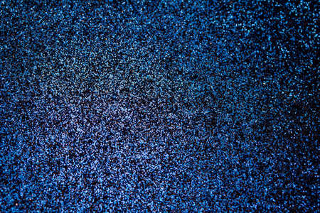 This image shows a full frame macro photographed sparkling blue color glitter surface background with bokeh.の写真素材
