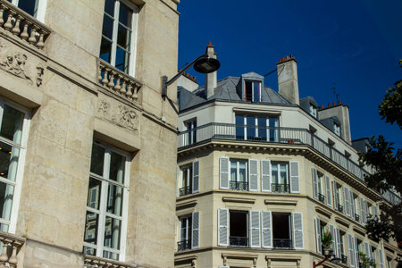 This image shows a close, upward exterior view of traditional building architecture in France, with...