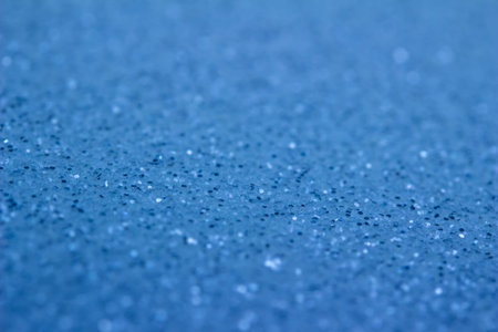 Full frame abstract background of shimmering blue glitter texture with selective focus