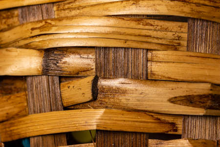 Full frame macro abstract background of rustic woven rattan cane basket texture with an uneven pattern surfaceの写真素材