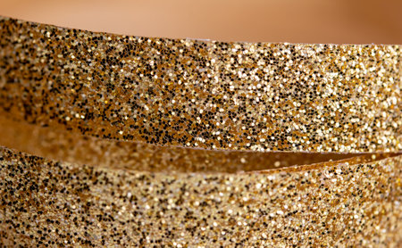 Full frame macro abstract texture background of sparkling gold color Christmas holiday fabric glitter ribbon with bokeh and copy spaceの写真素材