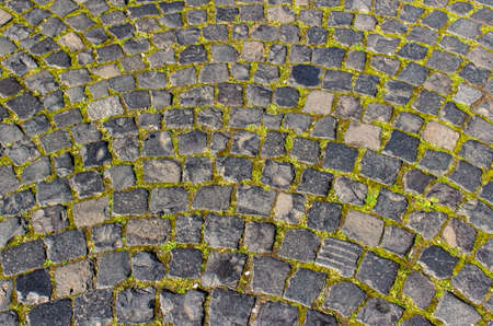 Close up, full frame texture background of a European cobblestone walkway, with small square stones arranged in a circular patternの写真素材