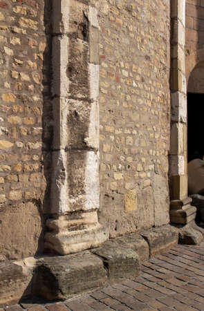 This image shows a full frame texture background of a weathered, but intact, medieval stone wall, with stone pillar moulding. (angle view)の写真素材