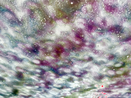 Texture background of abstract designs from water and soap suds on a vehicle windshield in an automated car washの写真素材
