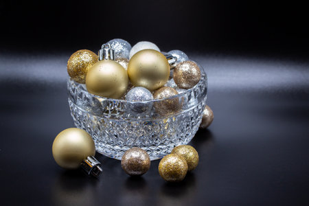Macro abstract defocused view of a beautiful small crystal bowl with sparkling glitter holiday balls, with white backgroundの写真素材
