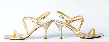 Woman golden shoes on white backgroundの写真素材