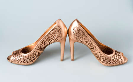 Woman gold shoes on gray backgroundの写真素材
