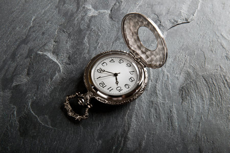 Pocket gray clock on dark gray slate texture