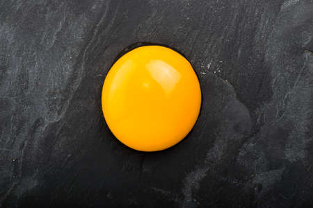 Raw egg close-up on blackの写真素材