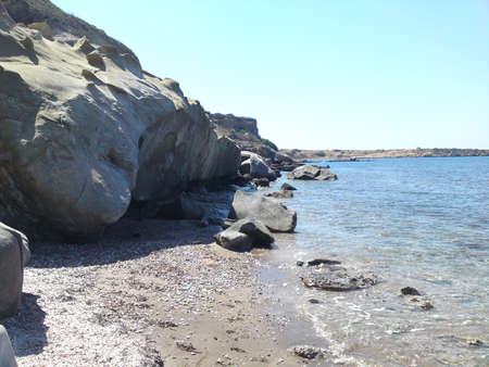 Rocky beach shoreline, blue sea and sky.の写真素材