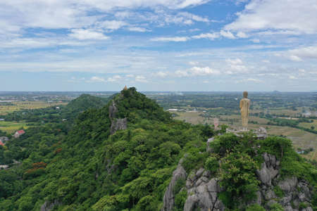 Scenic aerial view of buddhist statue above a mountain view in Ratchaburi Thailandの写真素材