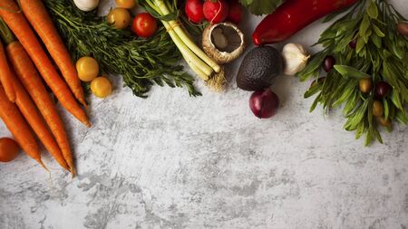 Healthy abundance of fresh-garden vegetables and herbs on grey surface.の写真素材